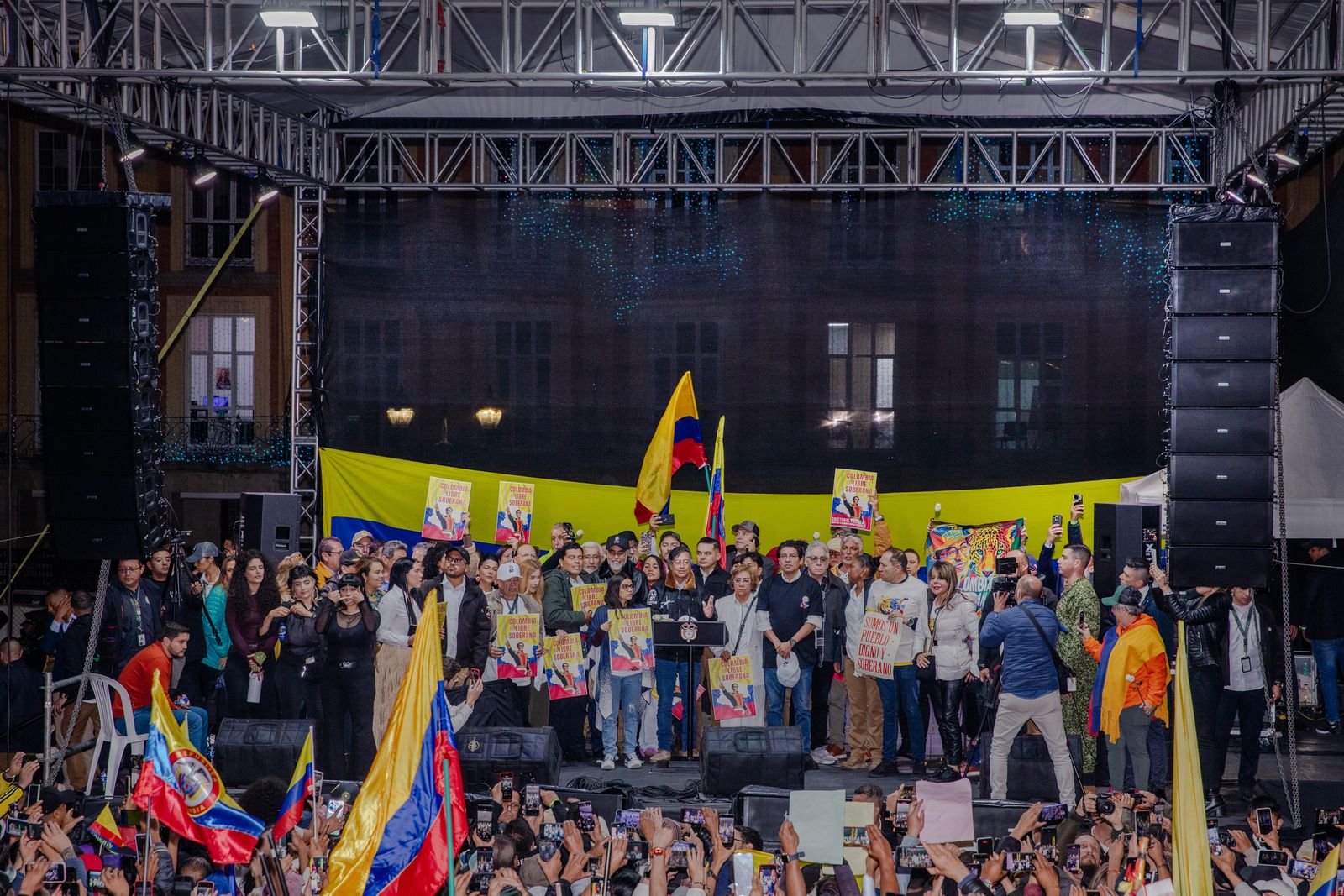 Large rally of people with many holding Colombian flags.